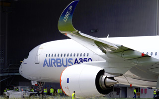 LAirbus A350, priv de roll-out mdiatis, sort du hangar de peinture