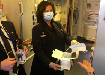 Un équipage d'Air France distribue des masques et du gel hydroalcoolique à l'embarquement